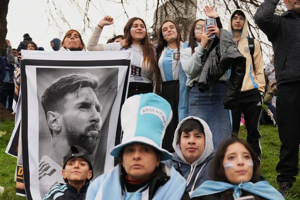 Los aficionados argentinos sostienen una foto de Lionel Messi