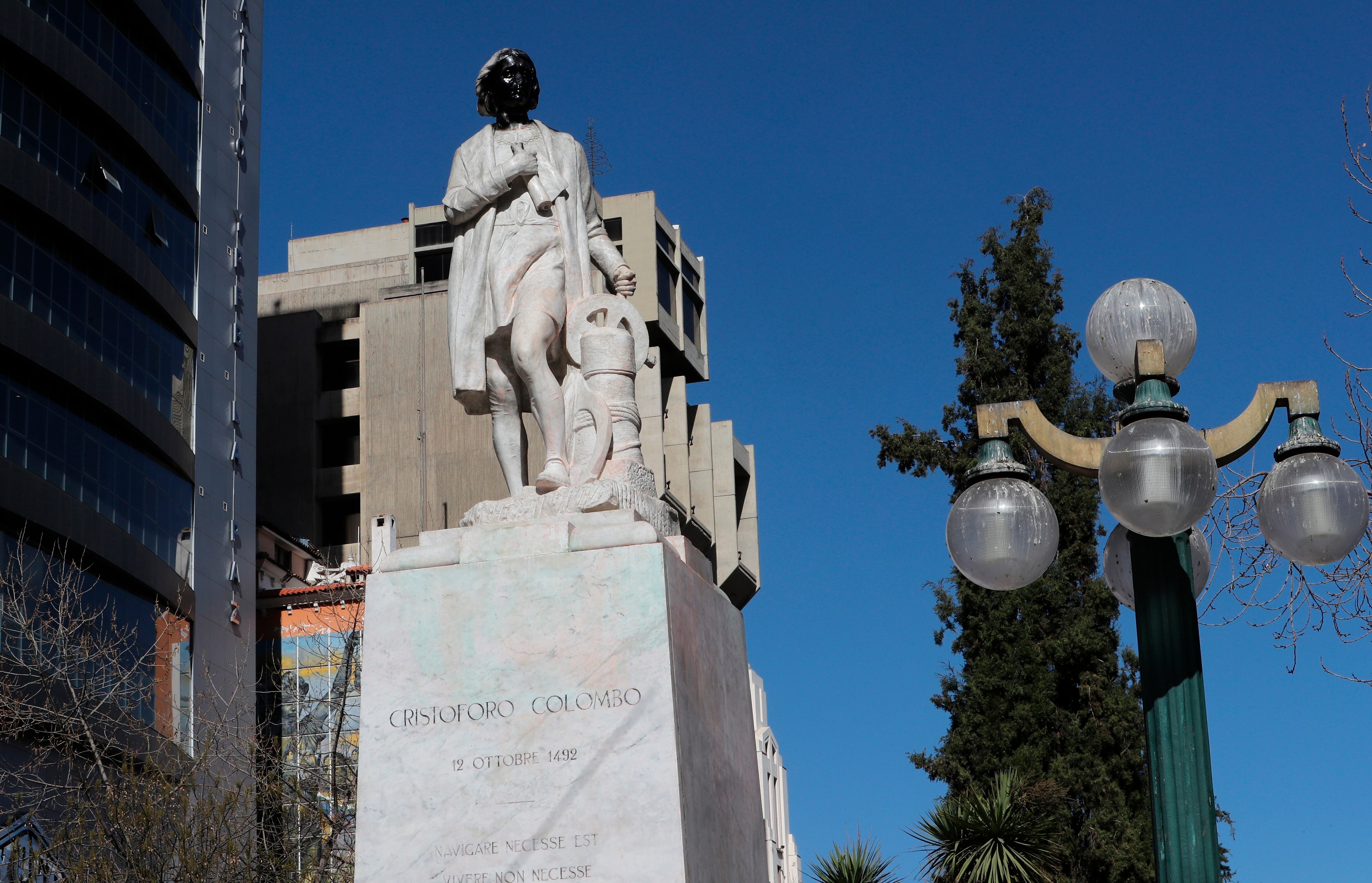 Fotografía de un monumento de Cristóbal Colón sin nariz y con el rostro pintado de negro