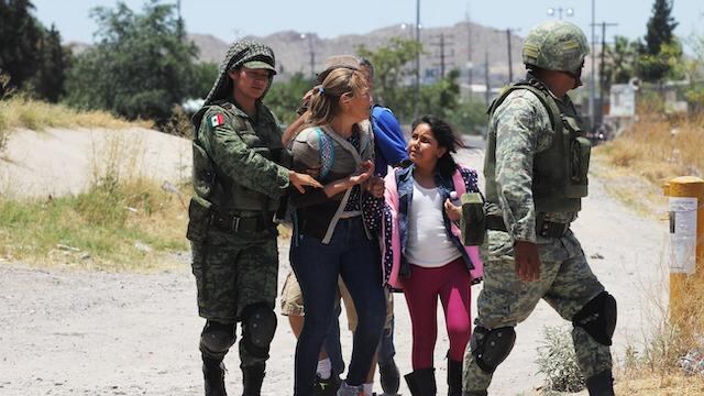 Elementos de la Guardia Nacional detienen a una mujer y una niña que intentaron cruzar el Río Bravo hacia Estados Unidos.