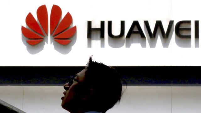 Un hombre pasa junto a una tienda Huawei en Beijing.