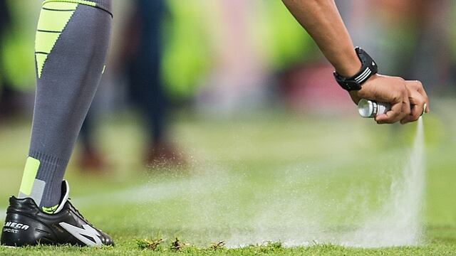 Árbitro pinta línea de barrera.