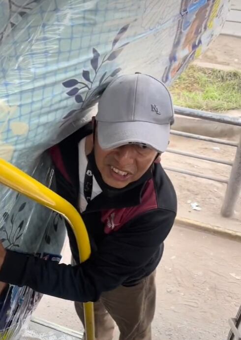 Hombre cargando colchón para subirse al camión