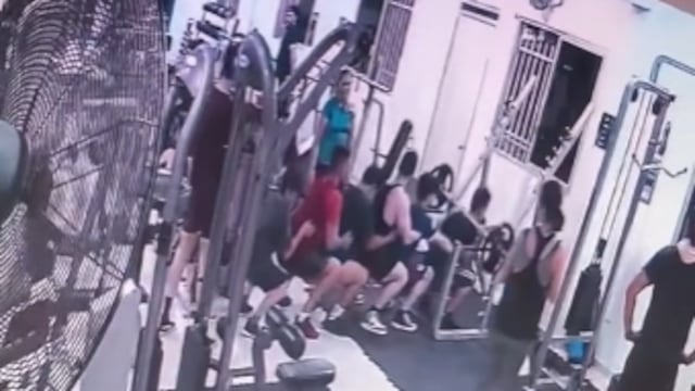 Hombres ayudando a otro con las pesas del gimnasio