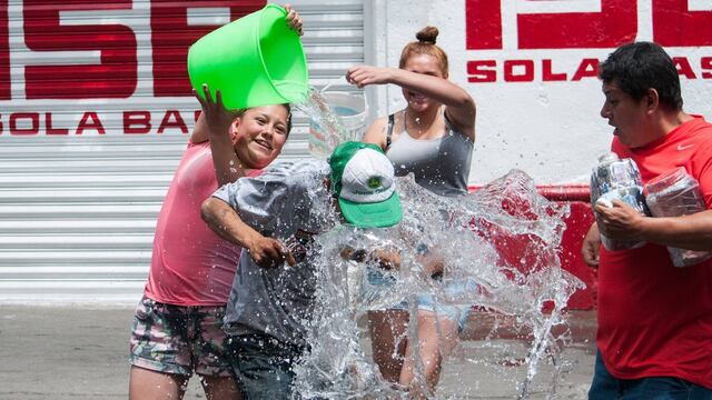 Gente mojándose en Sábado de Gloria. Advertencia sobre desperdicio de agua.