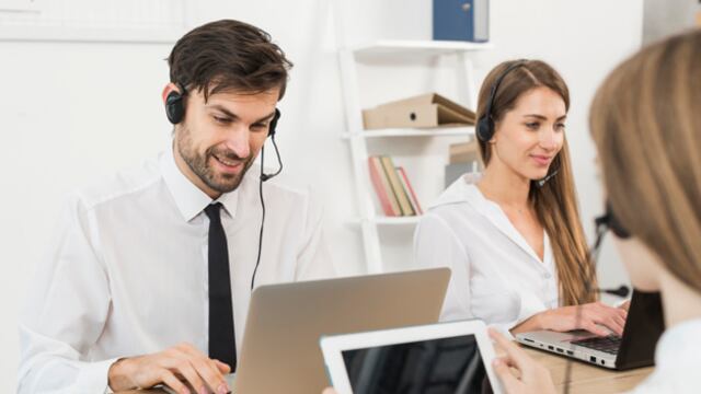 Trabajadores de call center sonriendo.