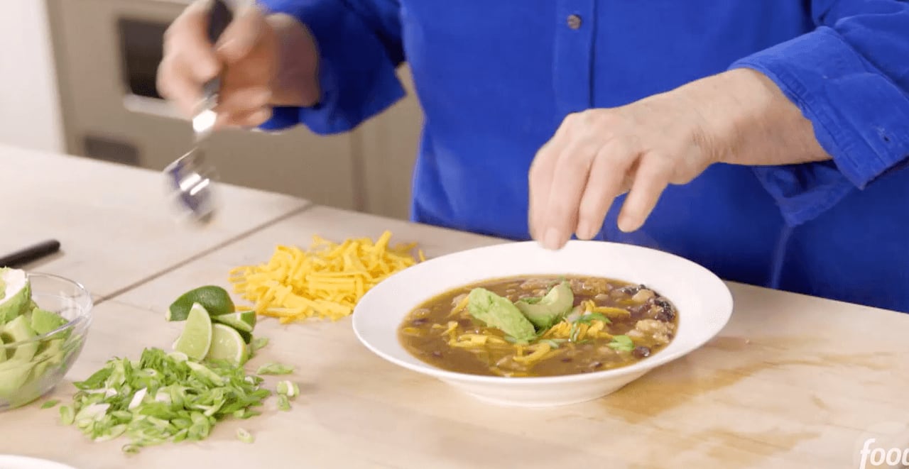 El platillo incluye totopos, frijoles, queso cheddar y salsa verde.