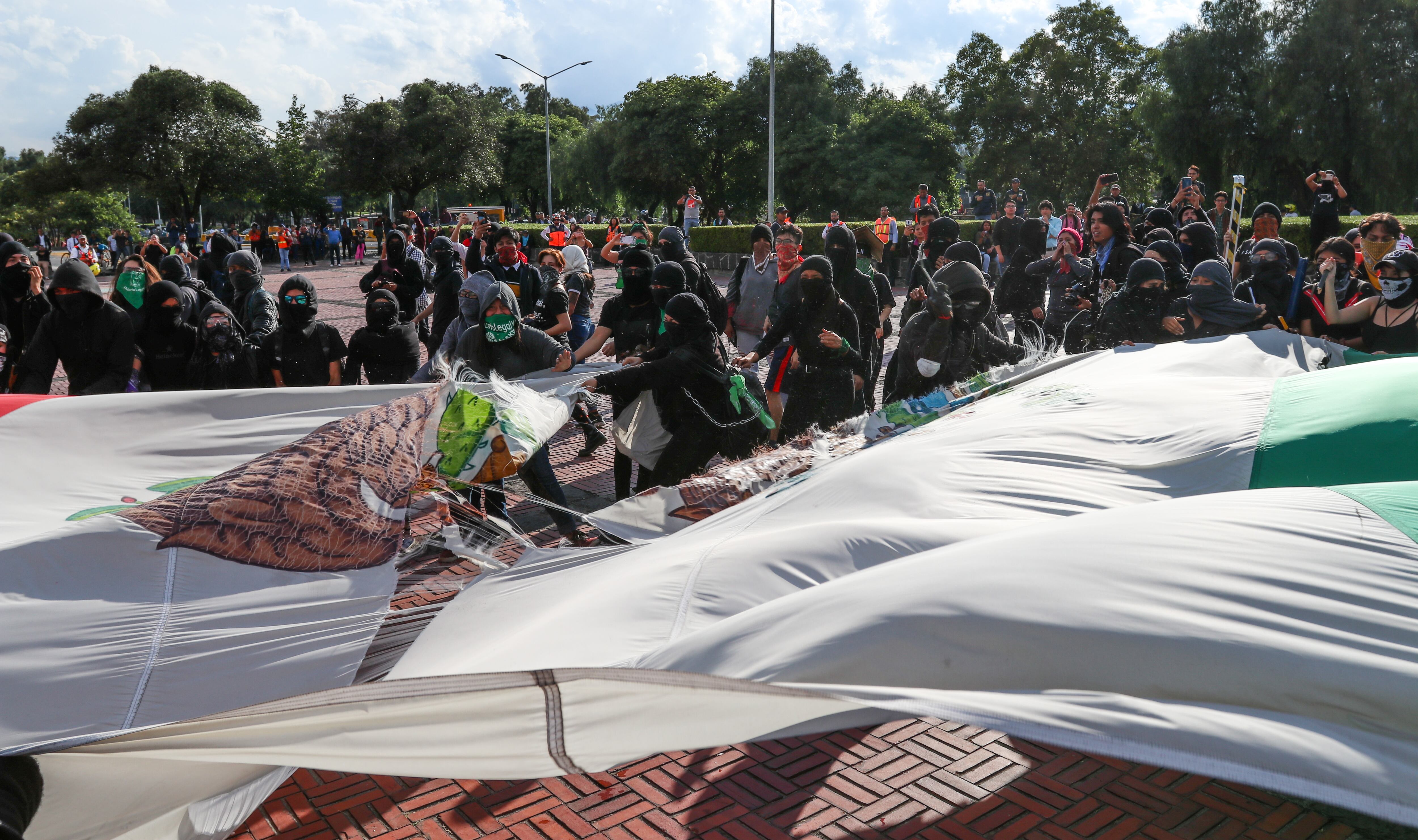 Vandalismo en la UNAM. Encapuchados queman bandera.