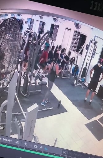Hombres ayudan a otro con las pesas del gimnasio