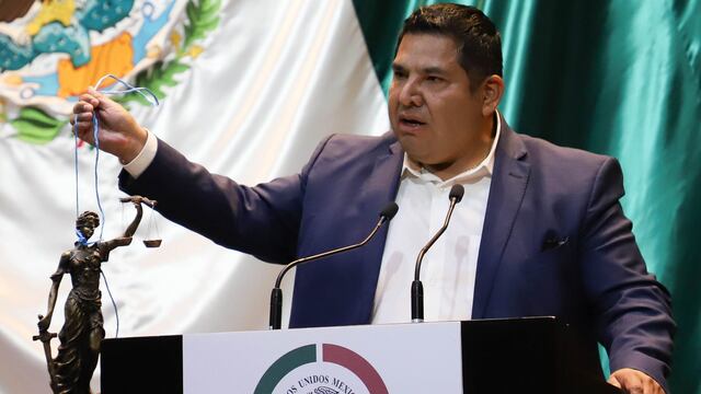 Eduardo Zarzosa, diputado del PRI, muestra una estatua de la Justicia amarrada del cuello