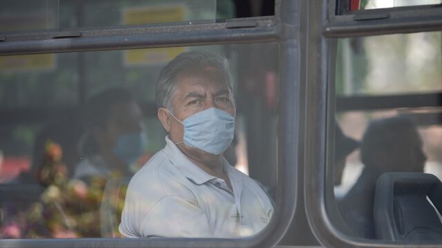 Un hombre se cubre la boca mientras viaja en transporte público en México