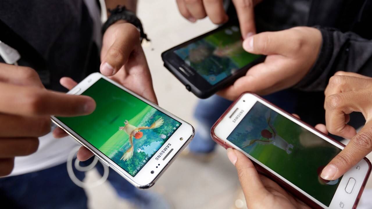 Personas jugando Pokémon Go en sus teléfonos celulares.