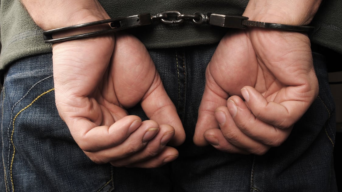 Esposado. Fueron capturados 3 por el asesinato de la esposa de un catedrático.