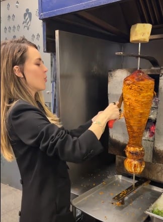 Belinda se pone de taquera al preparar su taco al pastor.