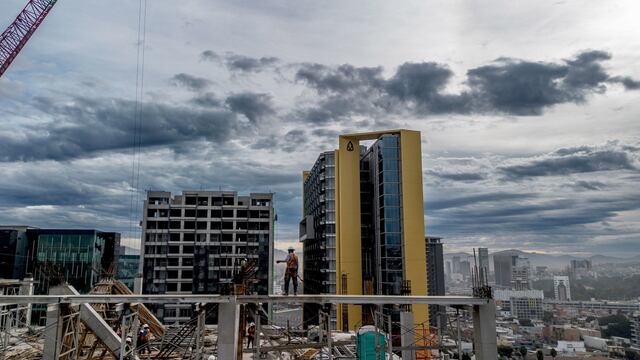 Desde las alturas del décimo piso de un edificio en construcción, un trabajador labora durante un día nublado en Tijuana