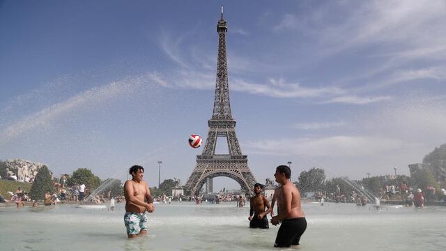 Franceses refrescándose cerca de la torre Eiffel