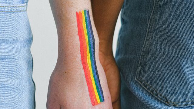 Manos con la bandera LGBT.