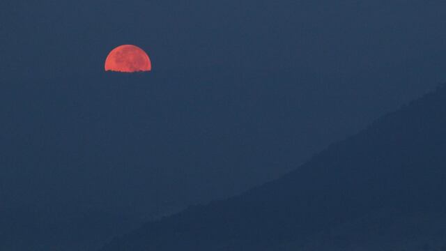 La luna llena adquiere un color naranja en el horizonte durante el amanecer de este día, la imagen tomada en San Pedro Tezontepec