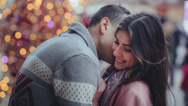 Mujer riendo mientras le dan un beso