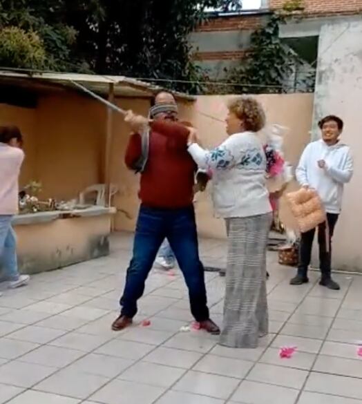 Le da santo palazo a una doñita en la piñata