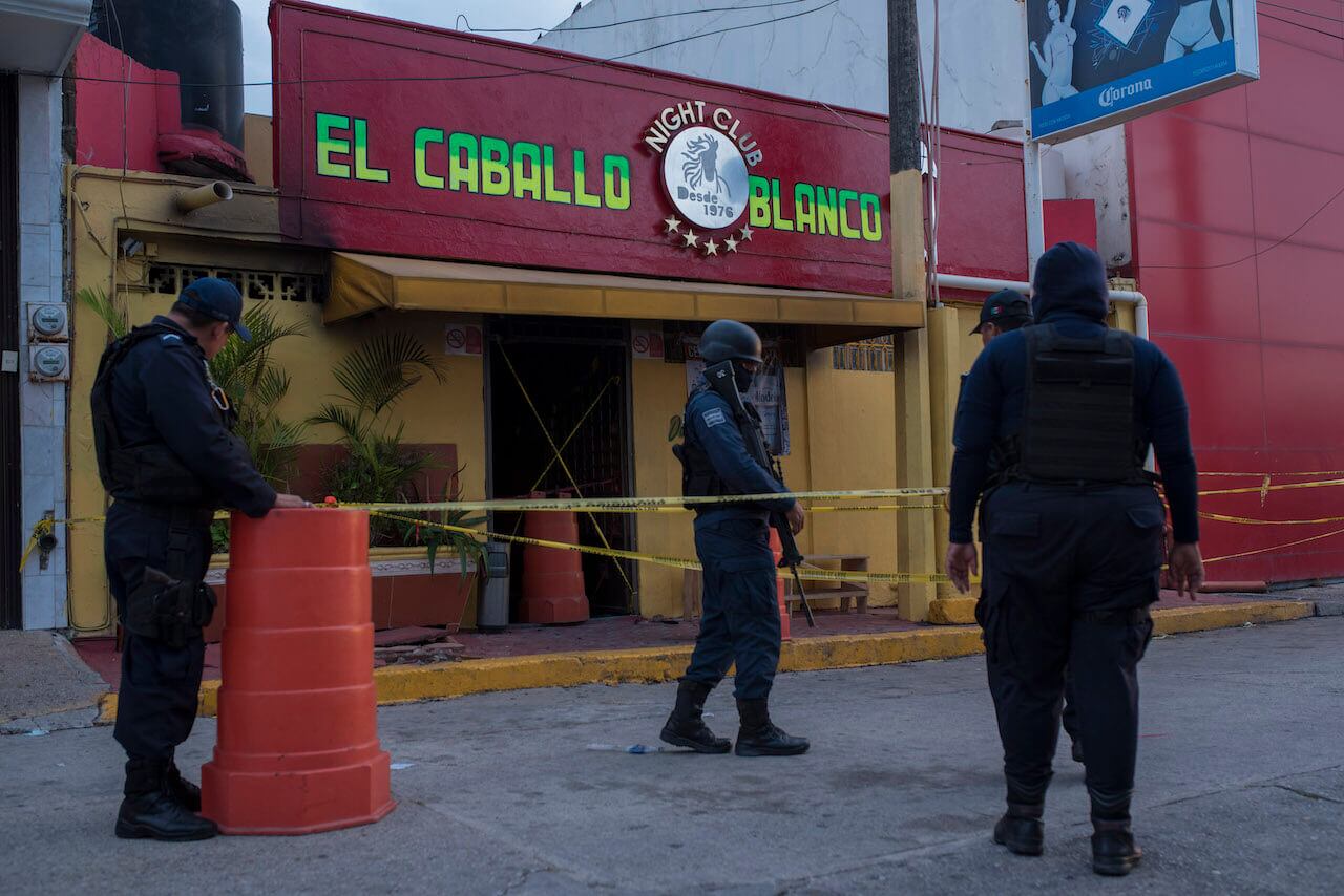 Policías resguardando el bar El Caballo Blanco.
