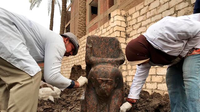 Fotografía del 11 de diciembre de 2019 proporcionada por el Ministerio de Antigüedades de Egipto de arqueólogos limpiando una pequeña estatua de granito de Ramsés II cerca de las antiguas pirámides de Giza, Egipto. (Ministerio de Antigüedades de Egipto/vía AP)