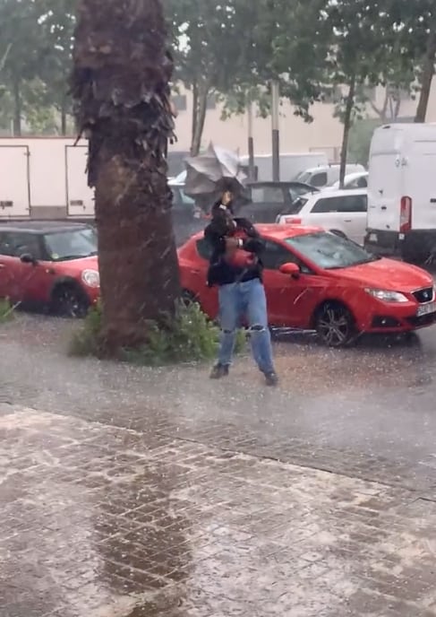 Sostiene su paraguas en medio de la lluvia