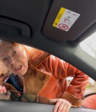 Mujer gritando a joven desde su auto