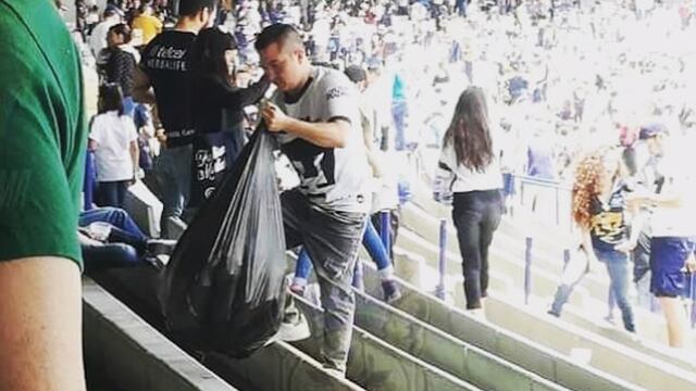 Afición de Pumas recogiendo basura del Olímpico Universitario