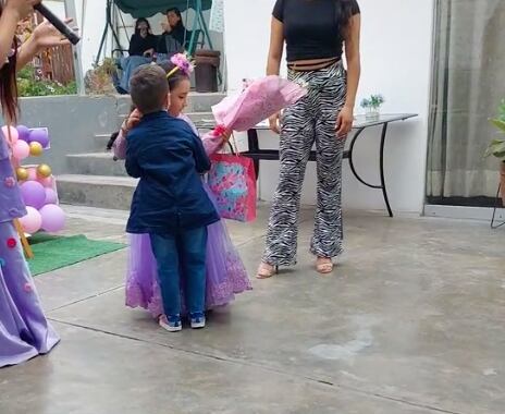 Pequeña cumpleañera recibe flores de su amigo