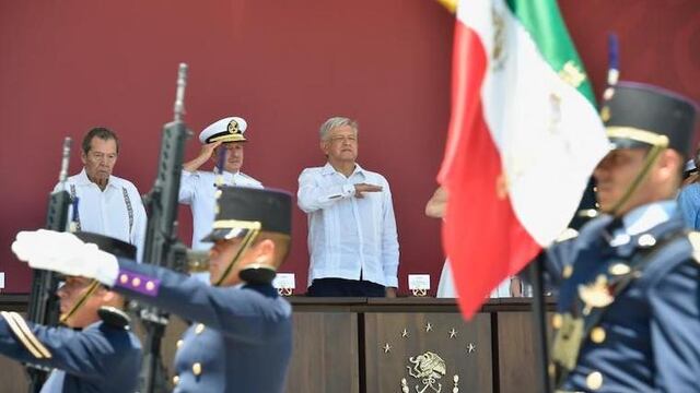 El presidente López Obrador saluda a la bandera en un acto en el puerto de Veracruz.