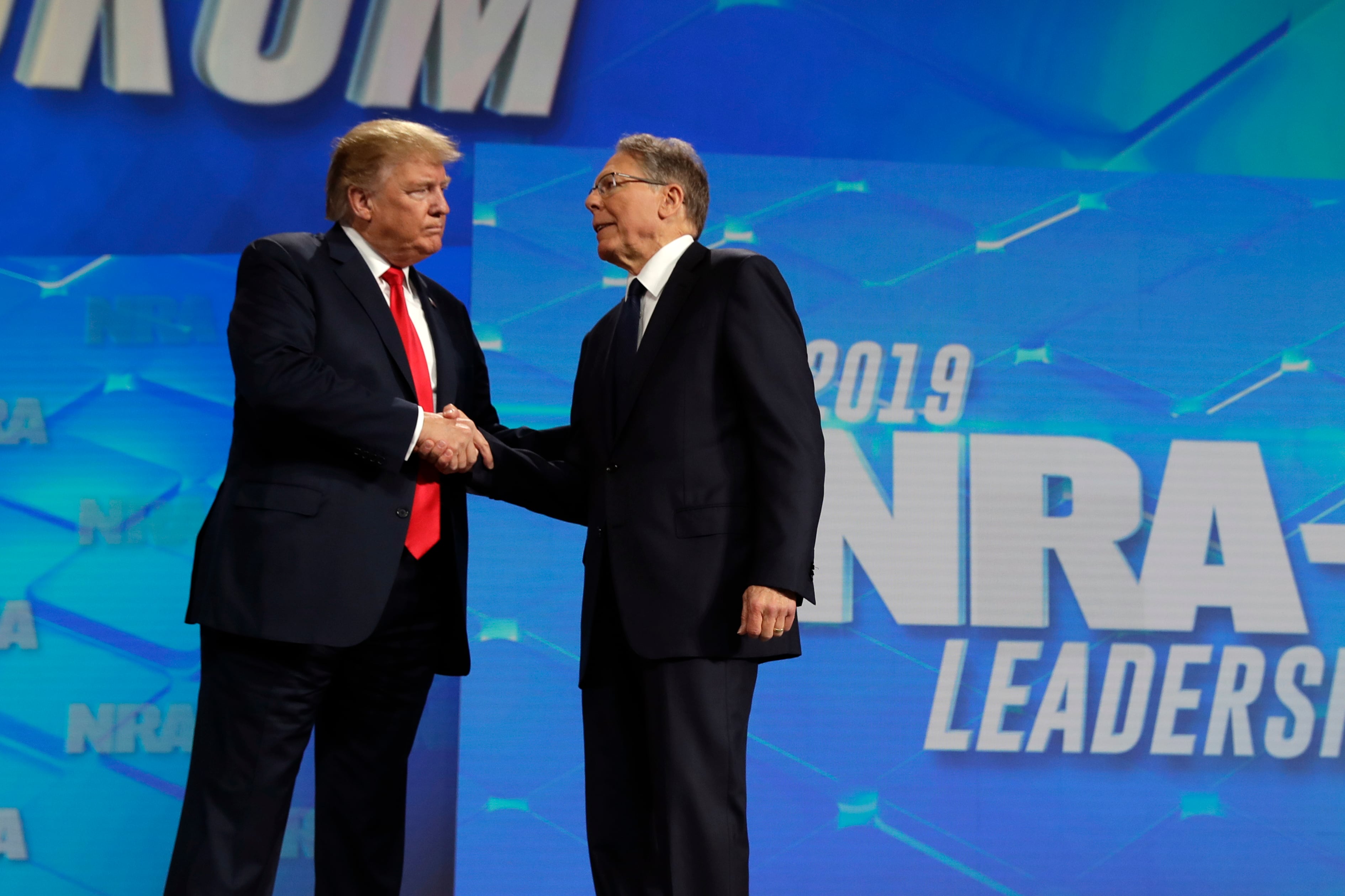 Donald Trump estrecha la mano del director general de la Asociación Nacional del Rifle, Wayne LaPierre.
