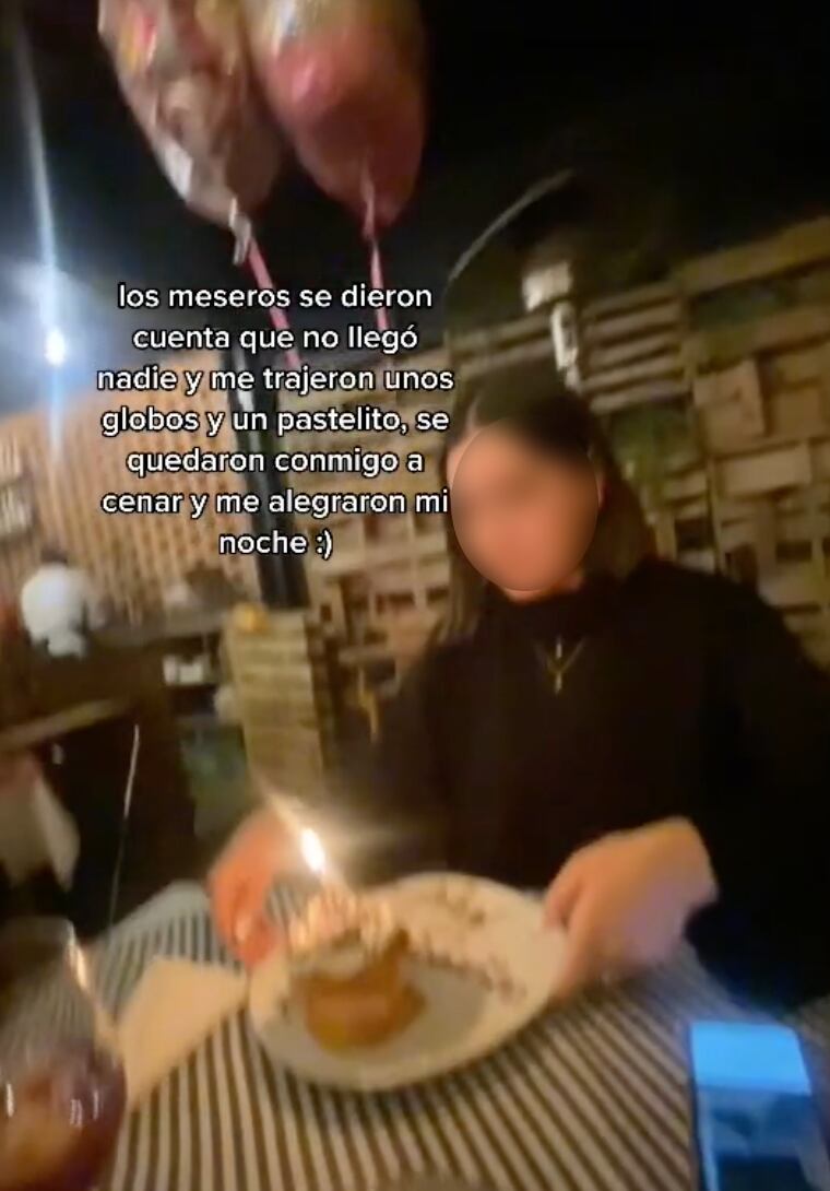 Joven con pastel de cumpleaños y globos