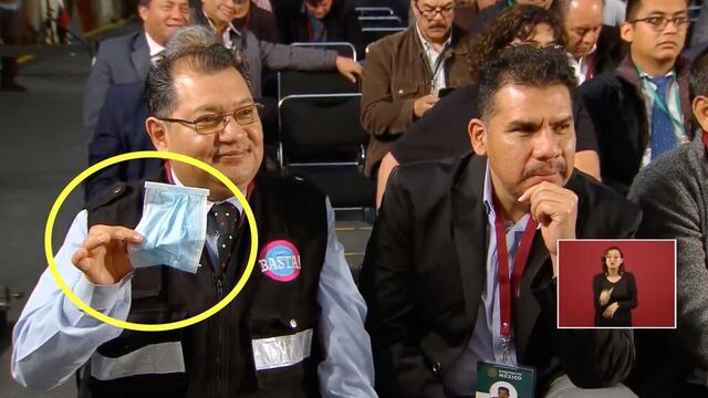 Un reportero sostiene un cubrebocas durante la conferencia en Palacio Nacional.