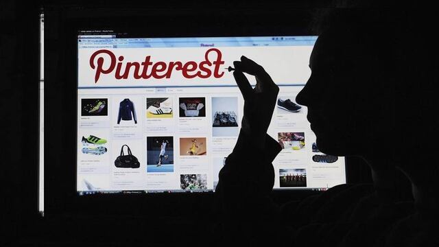 Monitor mostrando Pinterest mientras la sombra de una persona pretende hacer "pin".