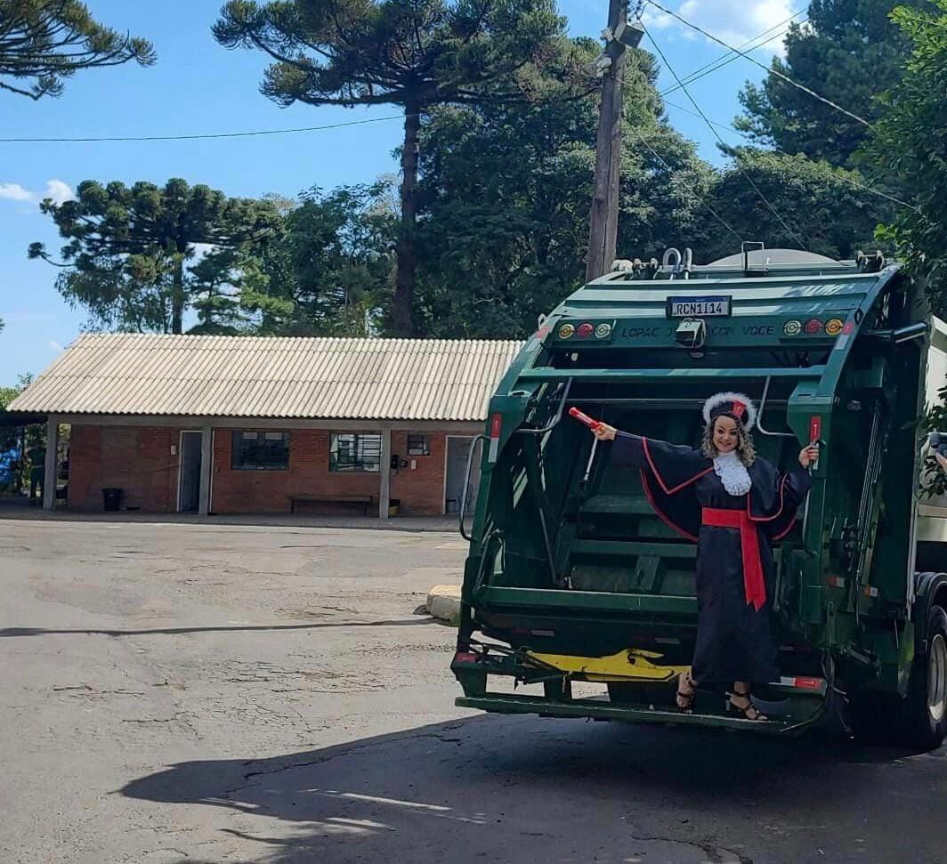 Recolectora de basura graduada como abogada tomándose fotos en camión donde trabajaba