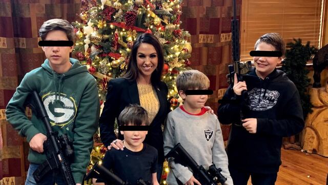 Lauren Boebert posando junto a sus hijos portando rifles con árbol de Navidad