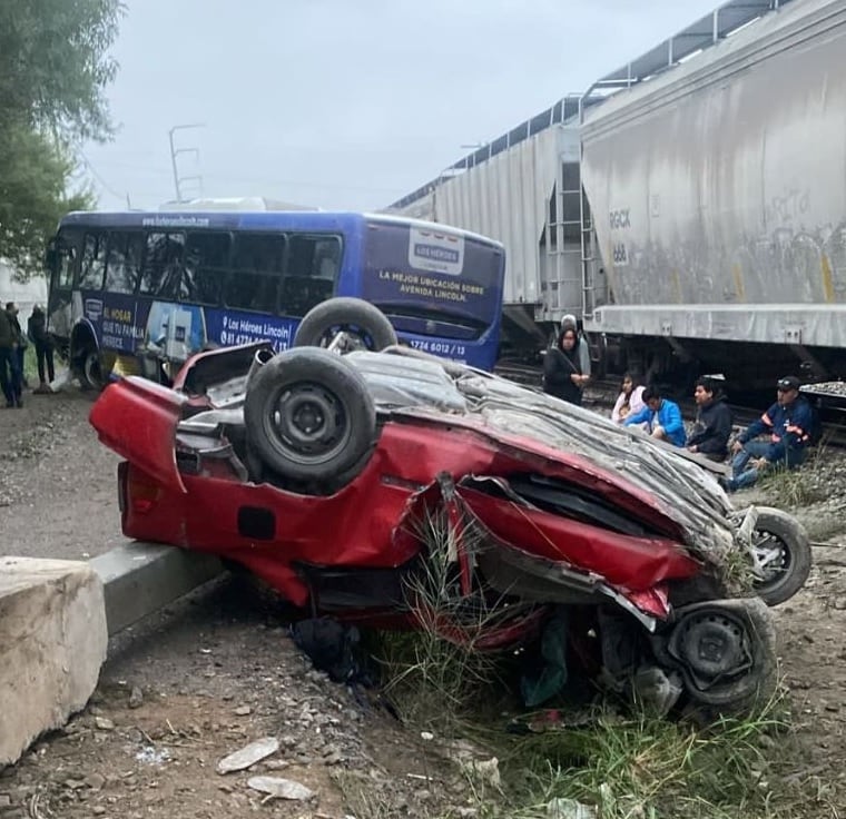 Vehículo Sedan rojo impactado por el tren