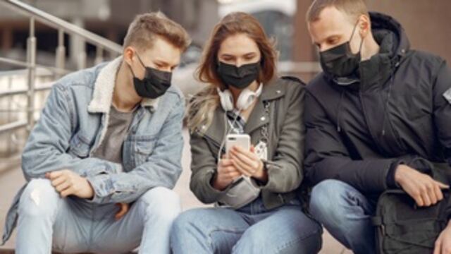 Personas con cubrebocas al aire libre.
