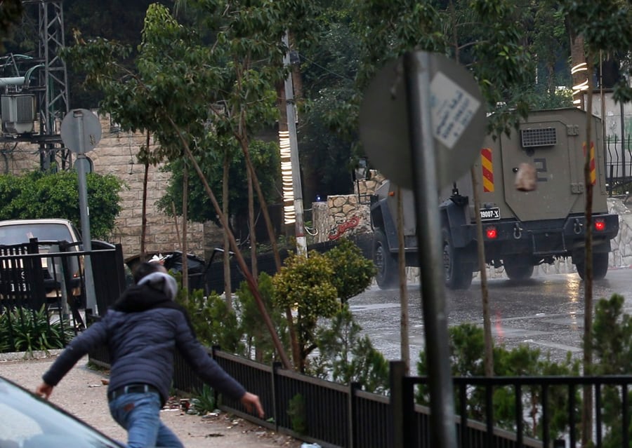 Un palestino arroja piedras a las tropas israelíes durante una redada en la ciudad de Naplusa, en Cisjordania