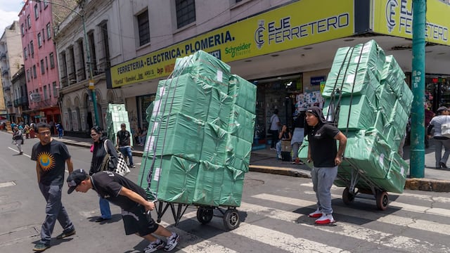 Jóvenes que trabajan de diableros en el Centro Histórico transportan mercancía proveniente de china