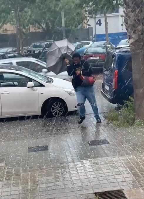 Sostiene su paraguas en medio de la lluvia