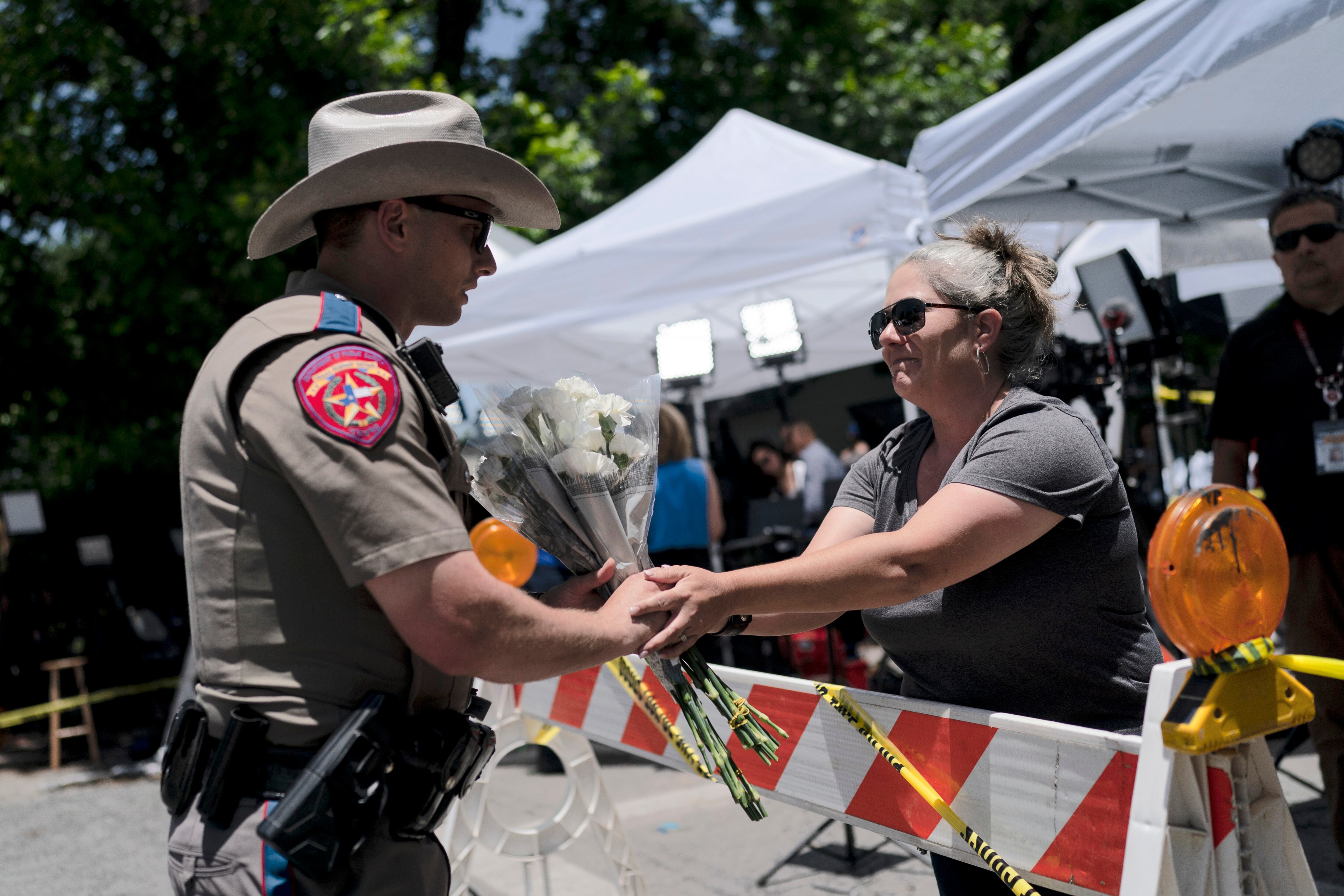 SPersonas  da flores a policías por víctimas de tiroteo en Texas.