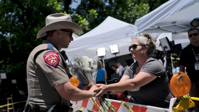 SPersonas  da flores a policías por víctimas de tiroteo en Texas.