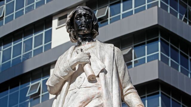 Fotografía de un monumento de Cristóbal Colón sin nariz y con el rostro pintado de negro