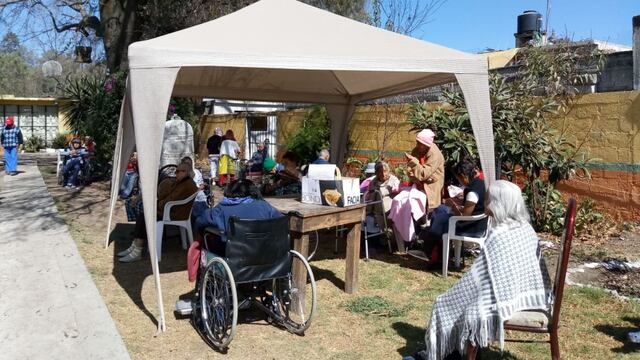 Los adultos mayores están en el patio en espera de la ayuda oficial.
