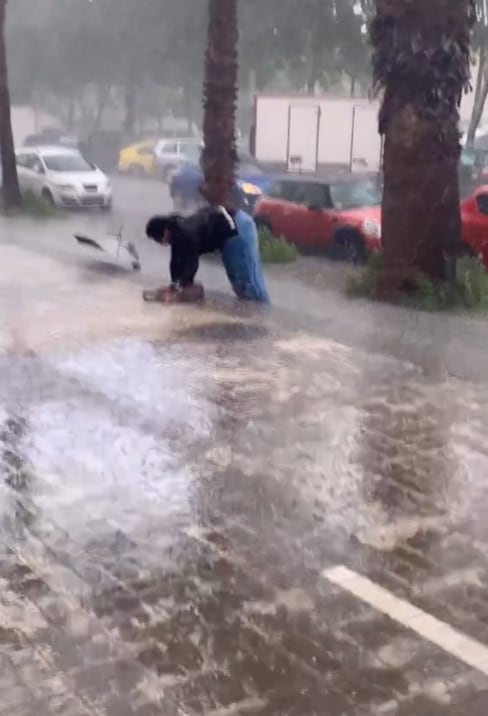 Sostiene su paraguas en medio de la lluvia