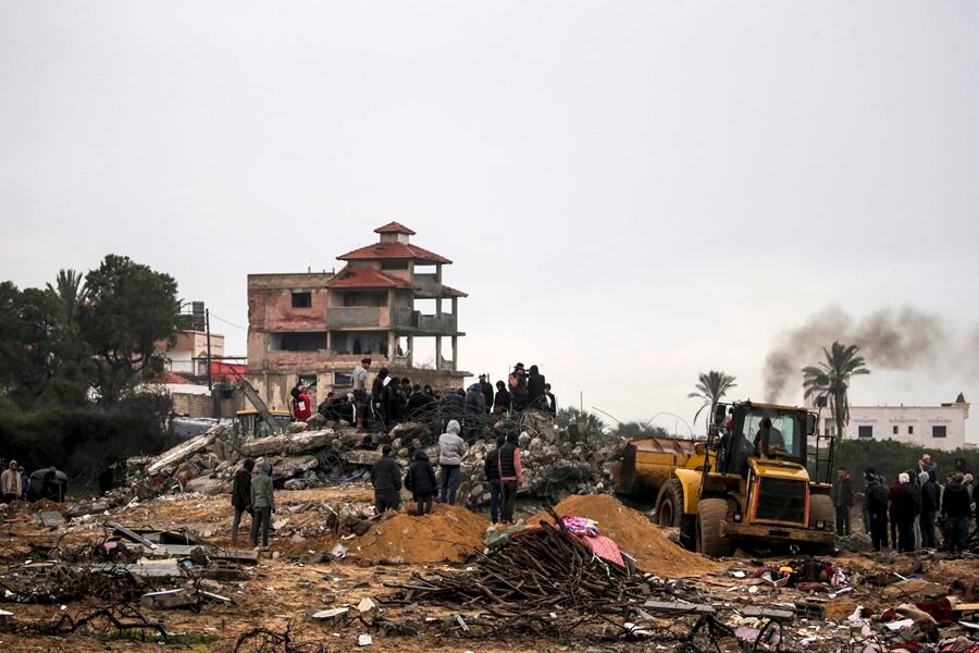 Palestinos buscan cadáveres y supervivientes entre los escombros de una casa destruida tras los ataques aéreos israelíes en Deir Al Balah, Franja de Gaza, este 29 de enero.