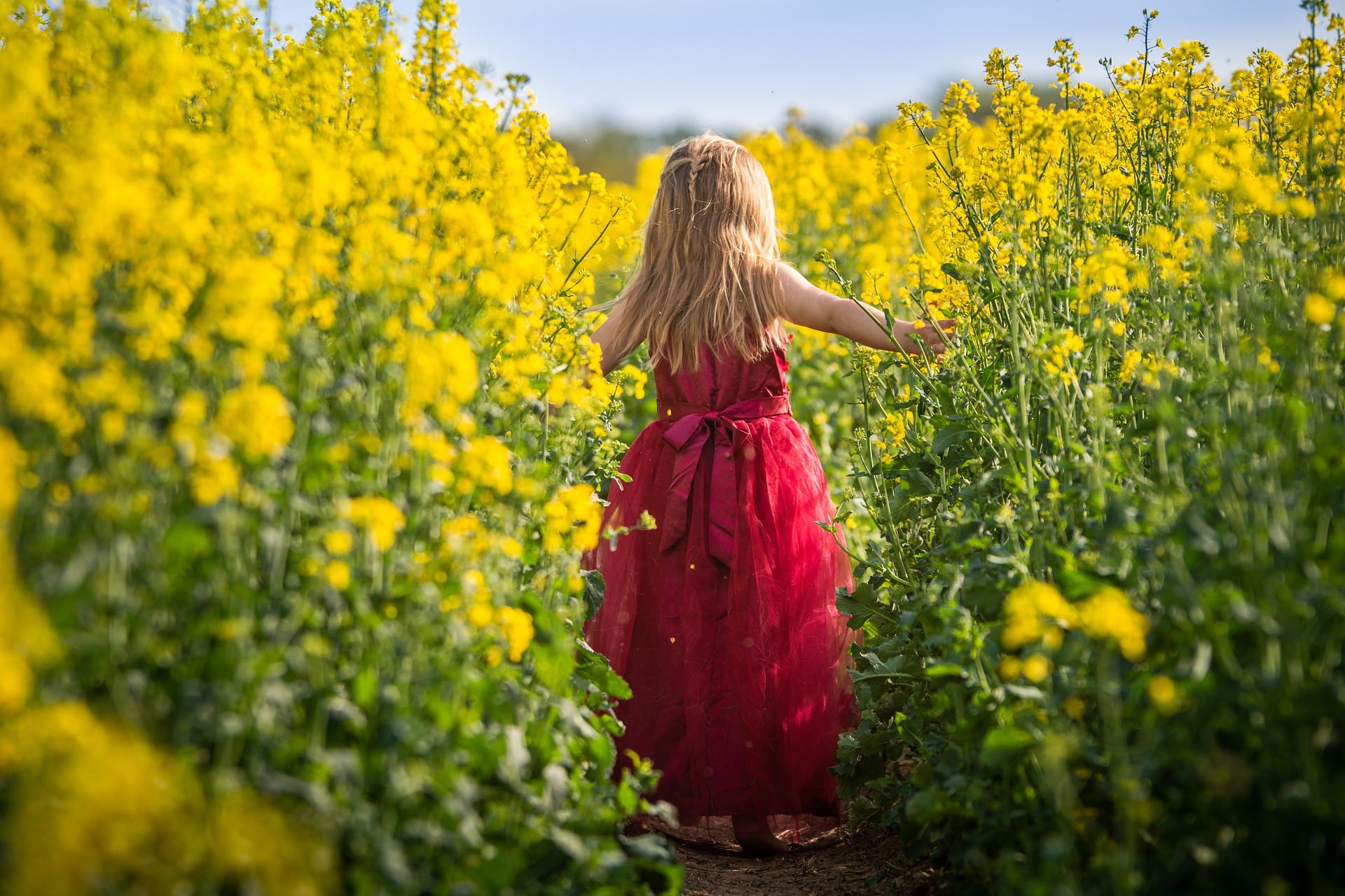 Niña en jardín con flores amarillas