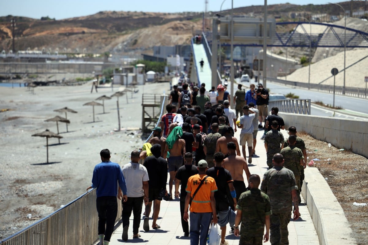 Migrantes cruzan por Ceuta.