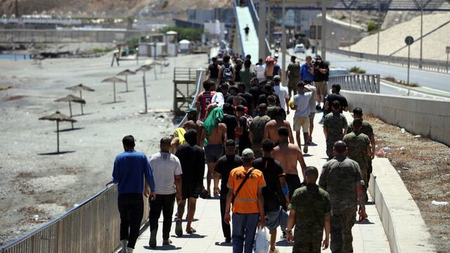 Migrantes cruzan por Ceuta.